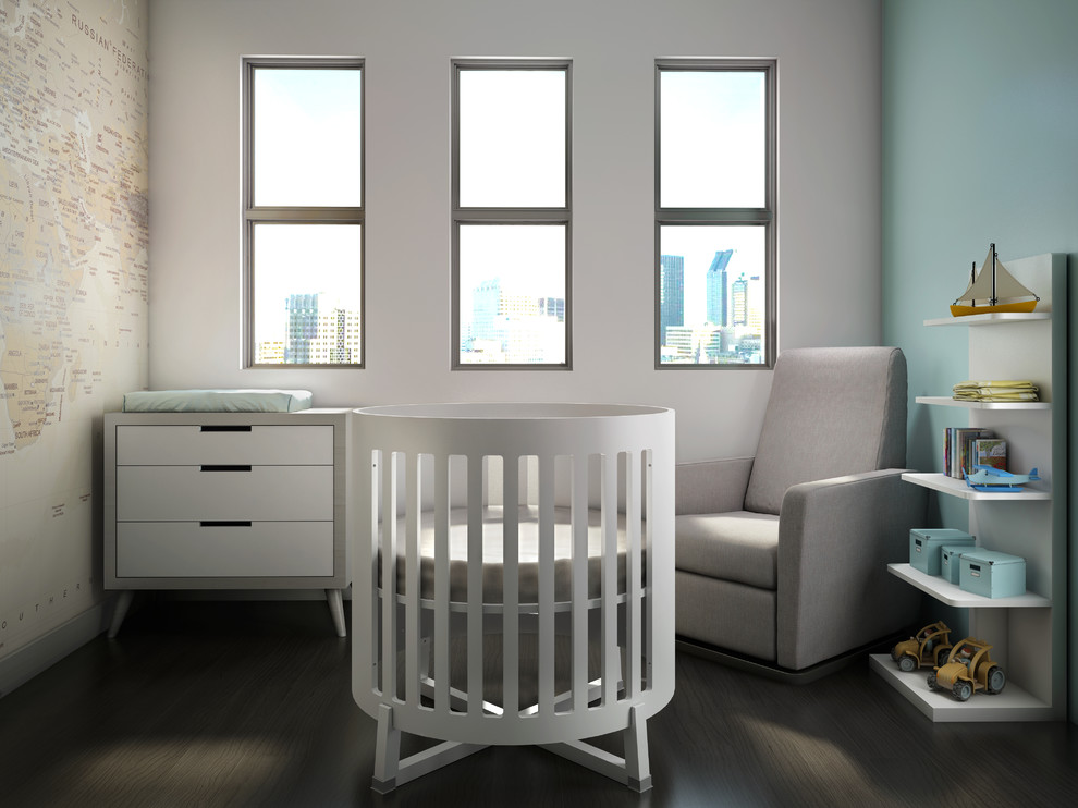 Ejemplo de habitación de bebé niño actual con paredes azules y suelo de madera oscura