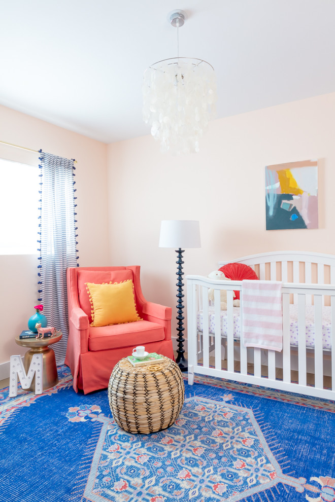 На фото: комната для малыша в стиле неоклассика (современная классика) с розовыми стенами для девочки с