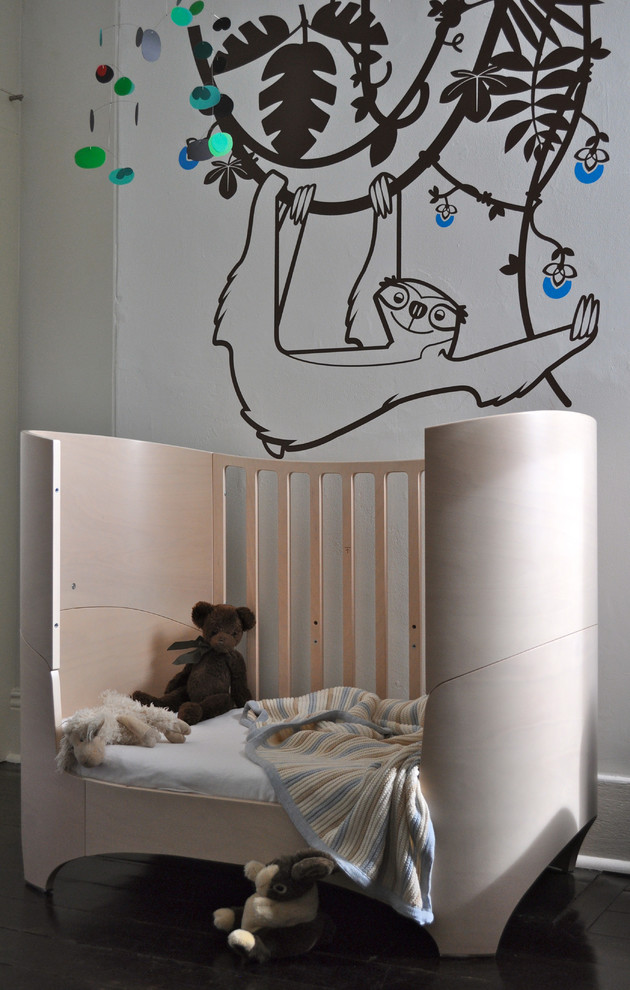 This is an example of a small midcentury nursery for boys in Melbourne with white walls and dark hardwood flooring.
