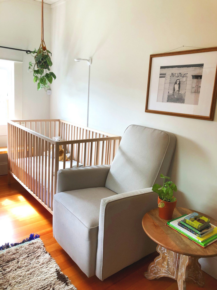 Design ideas for a small eclectic nursery for girls in Portland with white walls, medium hardwood flooring, brown floors and a timber clad ceiling.