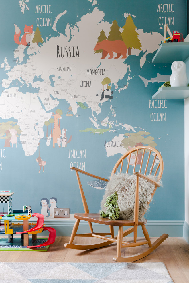 Diseño de habitación de bebé niño actual pequeña con paredes azules, suelo de madera clara y suelo marrón