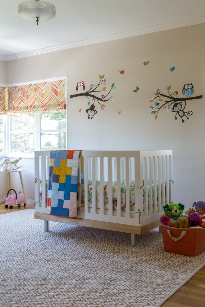 Immagine di una cameretta per neonati neutra contemporanea di medie dimensioni con pareti beige, moquette e pavimento beige