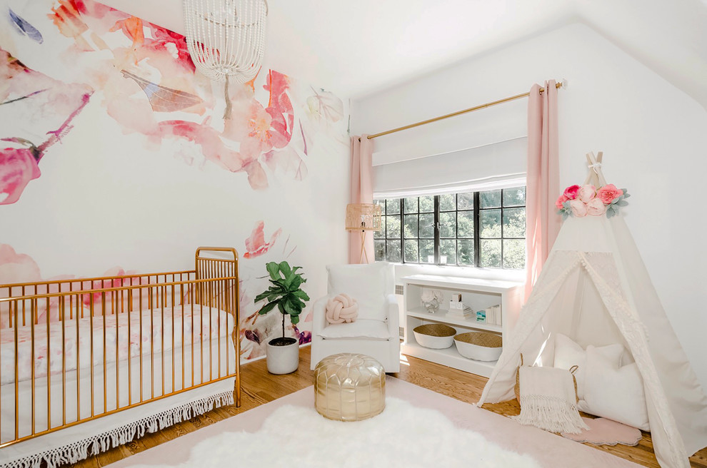 高級な広いトランジショナルスタイルのおしゃれな赤ちゃん部屋 (白い壁、無垢フローリング、女の子用、茶色い床) の写真
