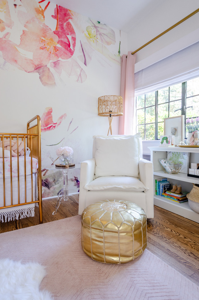 Réalisation d'une grande chambre de bébé fille tradition avec un mur blanc, un sol en bois brun et un sol marron.