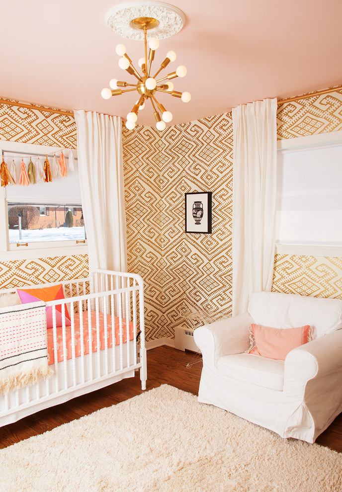 Modelo de habitación de bebé niña clásica renovada de tamaño medio con suelo de madera en tonos medios