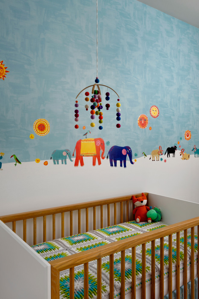 Exemple d'une grande chambre de bébé neutre rétro avec un mur multicolore, moquette et un sol multicolore.