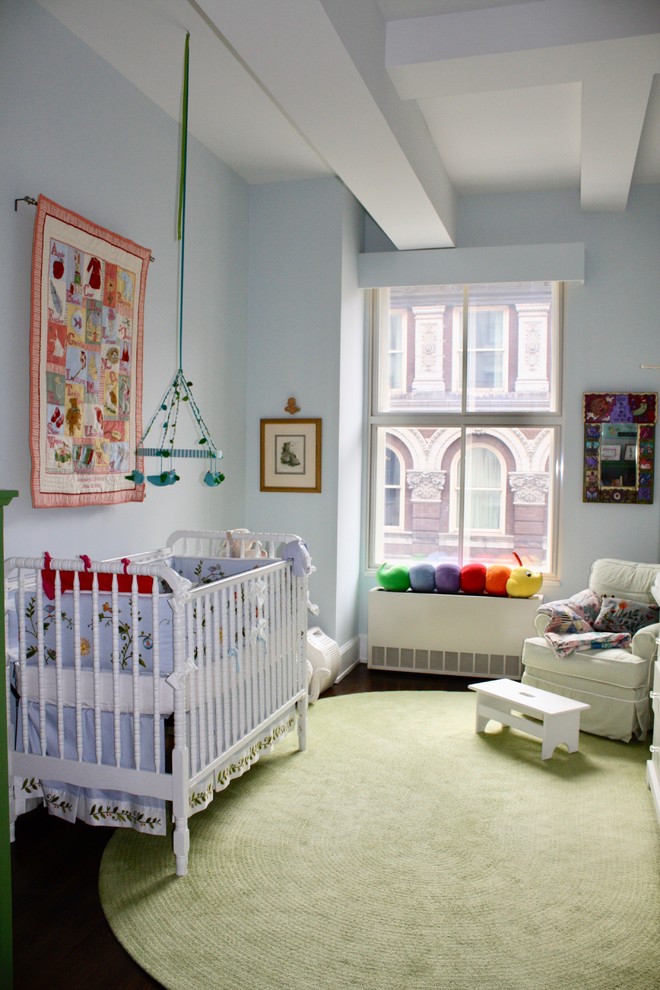 Foto de habitación de bebé neutra tradicional renovada de tamaño medio con paredes azules, suelo de madera oscura y suelo marrón