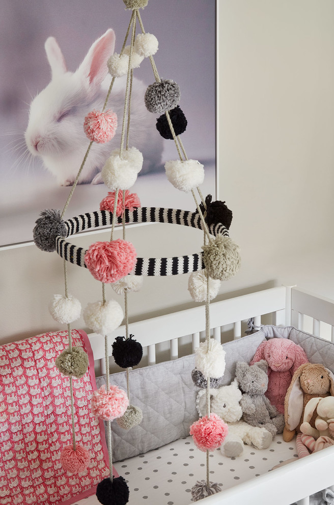 This is an example of a medium sized contemporary nursery for girls in Chicago with grey walls, dark hardwood flooring and grey floors.