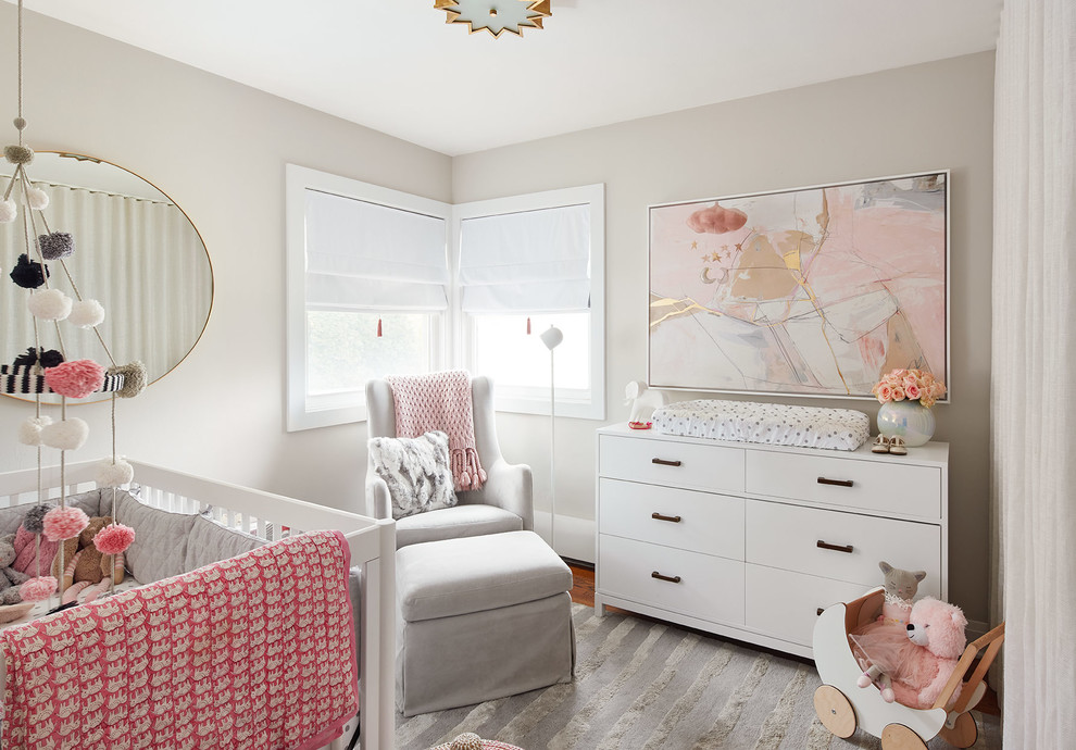 Idée de décoration pour une chambre de bébé fille design de taille moyenne avec un mur gris, parquet foncé et un sol gris.