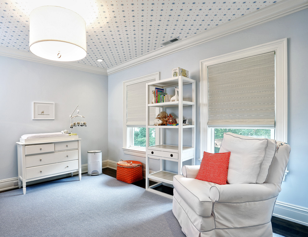 Ejemplo de habitación de bebé neutra clásica con paredes azules y suelo de madera oscura