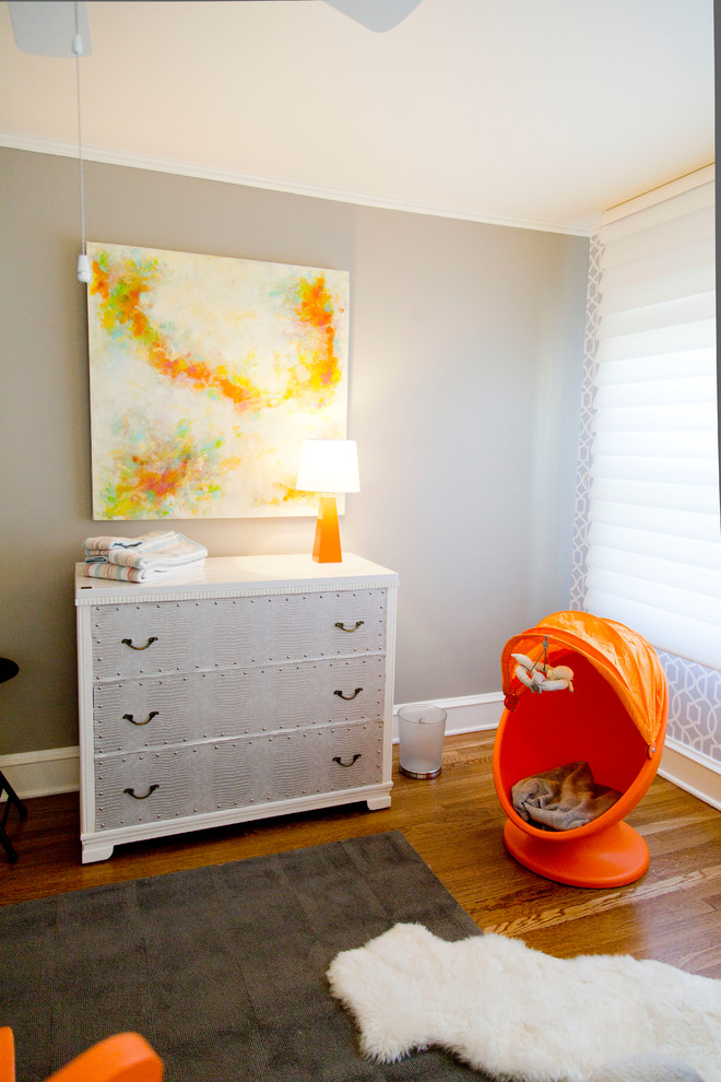 Diseño de habitación de bebé neutra clásica renovada grande con paredes grises y suelo de madera en tonos medios