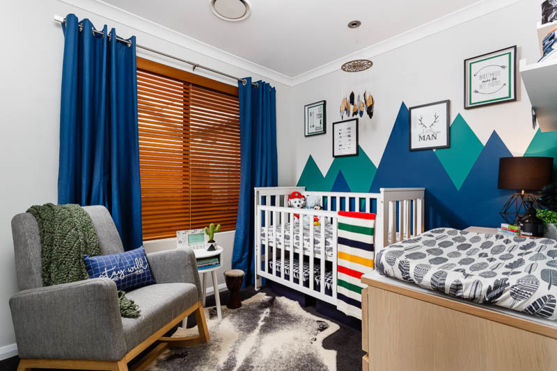 Immagine di una piccola cameretta per neonato classica con pareti blu e moquette