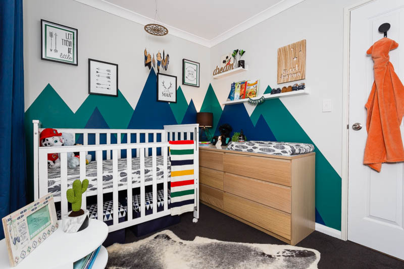 Aménagement d'une petite chambre de bébé garçon classique avec un mur bleu et moquette.
