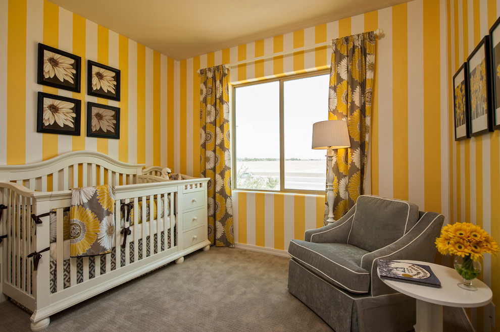 Esempio di una cameretta per neonata chic con pareti gialle e moquette