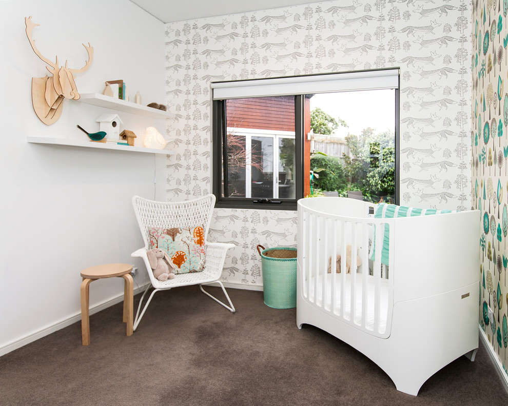 Modelo de habitación de bebé neutra actual pequeña con paredes multicolor, moqueta y suelo marrón