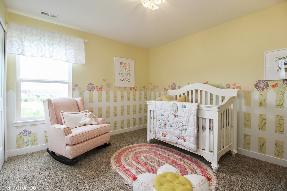 Aménagement d'une chambre de bébé fille classique avec un mur jaune, moquette et un sol beige.