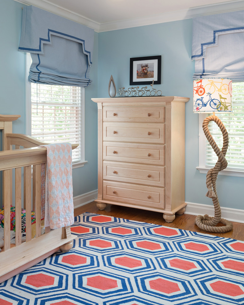 This is an example of a medium sized traditional gender neutral nursery in St Louis with blue walls and medium hardwood flooring.