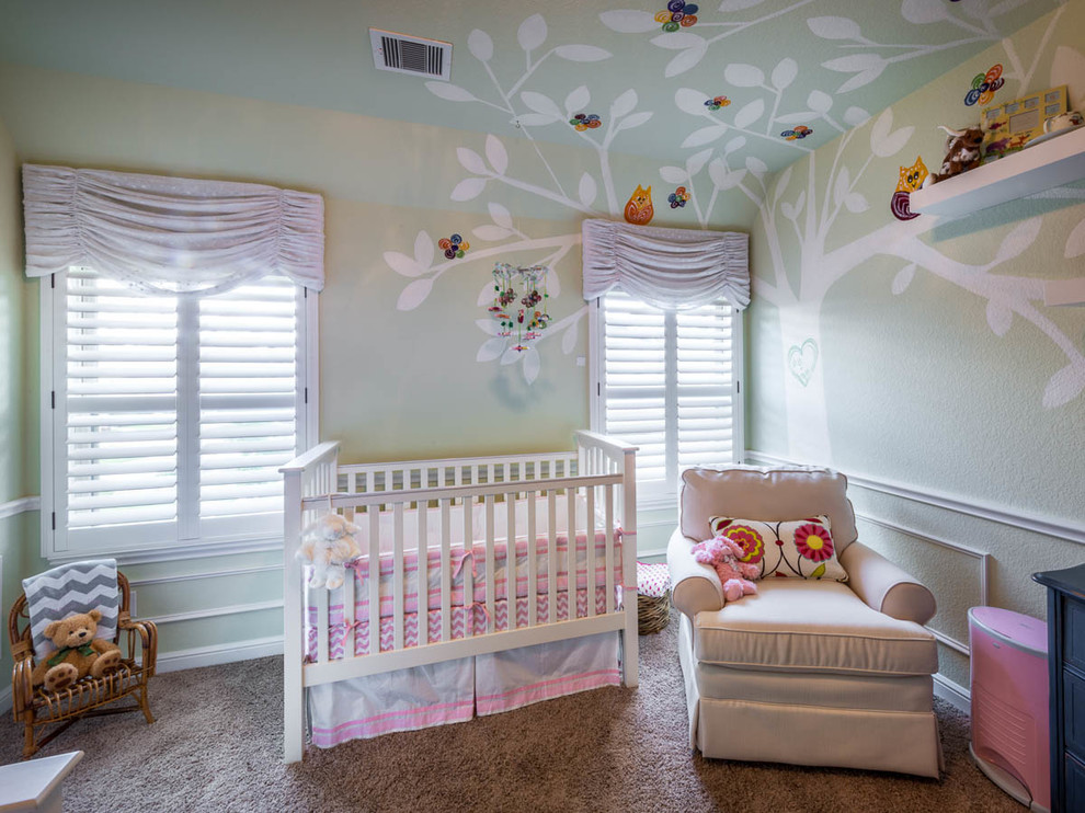 Imagen de habitación de bebé niña clásica renovada grande con paredes verdes y moqueta