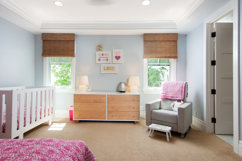 Cette image montre une chambre de bébé fille traditionnelle avec un mur bleu, moquette et un sol beige.