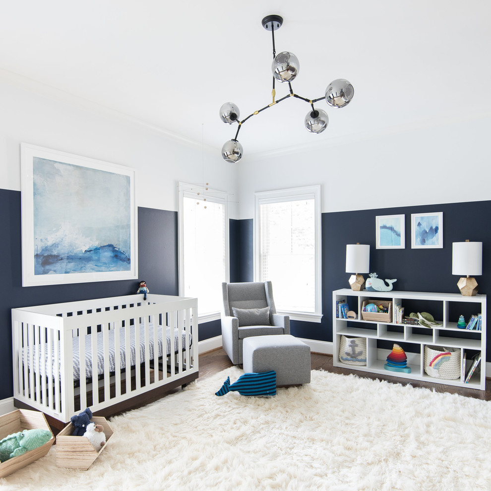 Modelo de habitación de bebé neutra tradicional renovada con paredes azules, suelo de madera oscura y suelo blanco