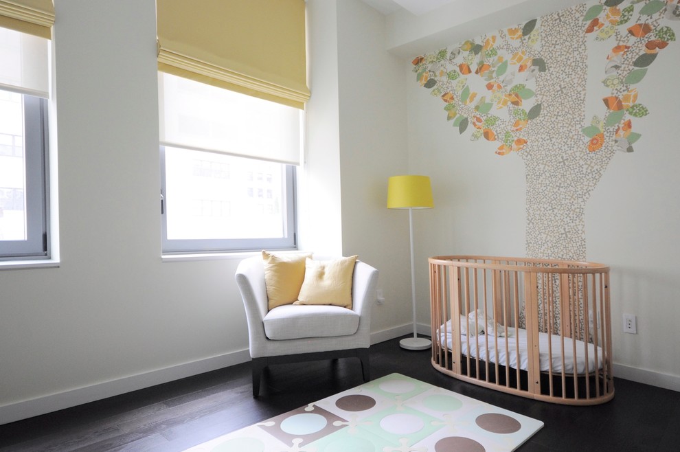 Cette photo montre une chambre de bébé neutre moderne de taille moyenne avec un mur multicolore et parquet foncé.