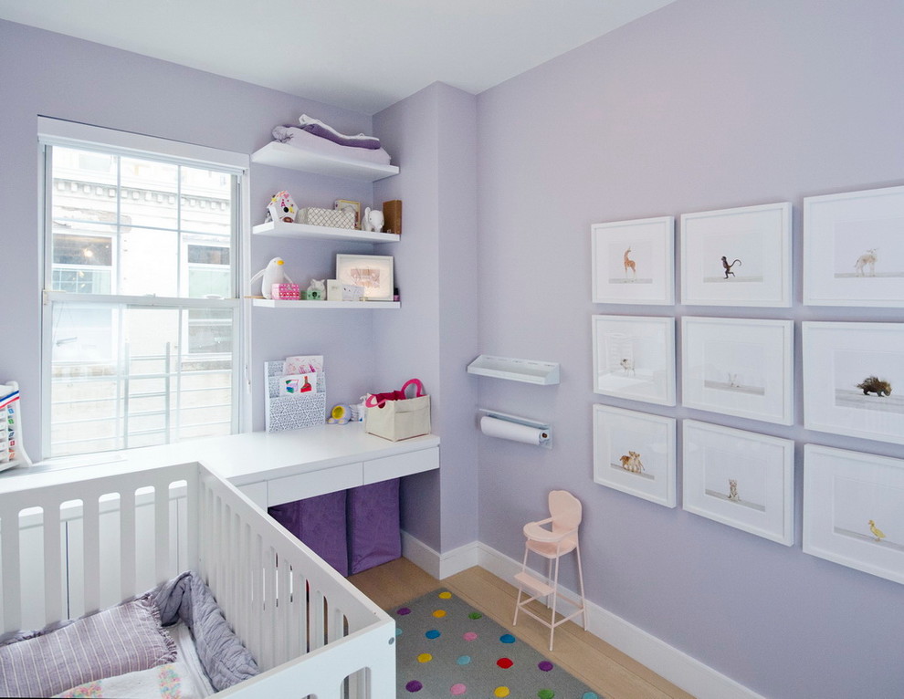 Immagine di una piccola cameretta per neonati neutra scandinava con pareti viola e parquet chiaro