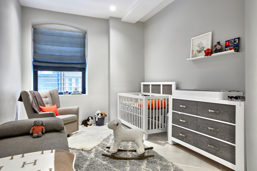 Neutrales, Kleines Modernes Babyzimmer mit grauer Wandfarbe, hellem Holzboden und grauem Boden in New York