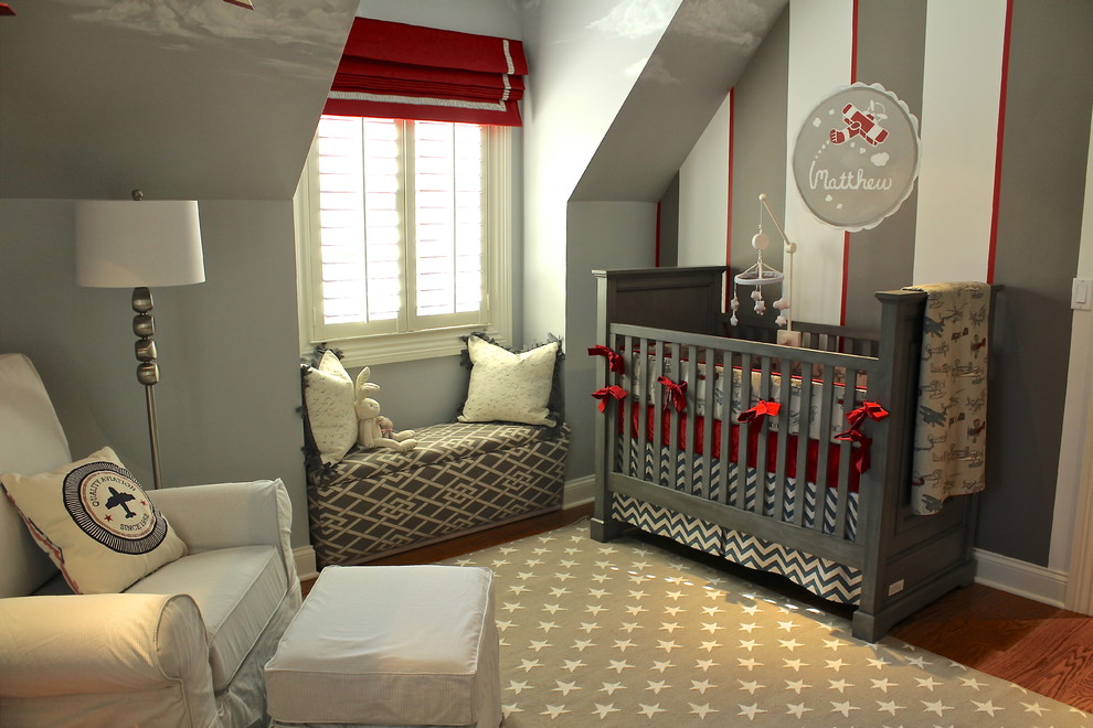 Aménagement d'une petite chambre de bébé garçon classique avec un mur multicolore et un sol en bois brun.