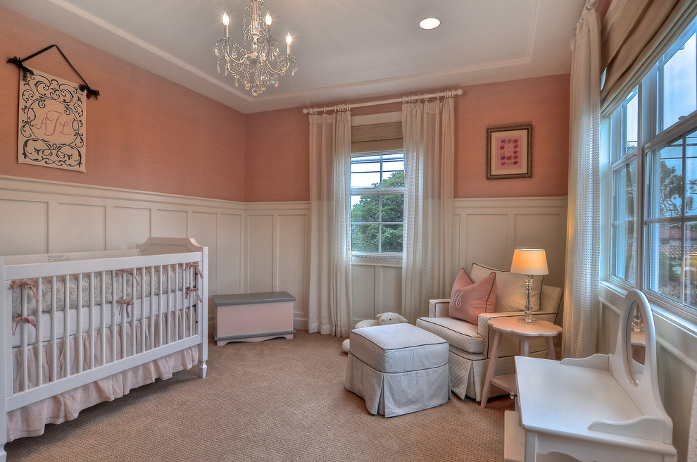 Example of a classic girl carpeted and beige floor nursery design in Orange County with pink walls