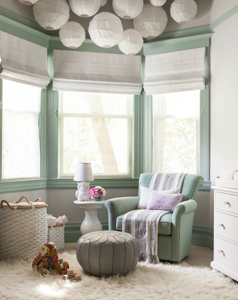 Immagine di una cameretta per neonati neutra classica con pareti verdi e moquette