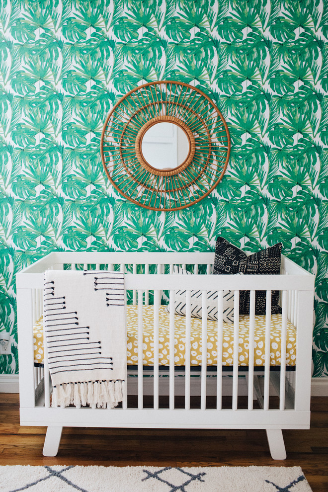 Imagen de habitación de bebé neutra ecléctica de tamaño medio con paredes beige y suelo de madera en tonos medios
