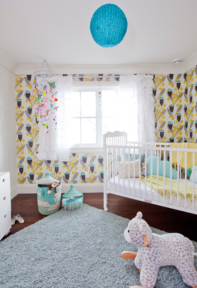 Idee per una cameretta per neonata chic con pareti multicolore e parquet scuro