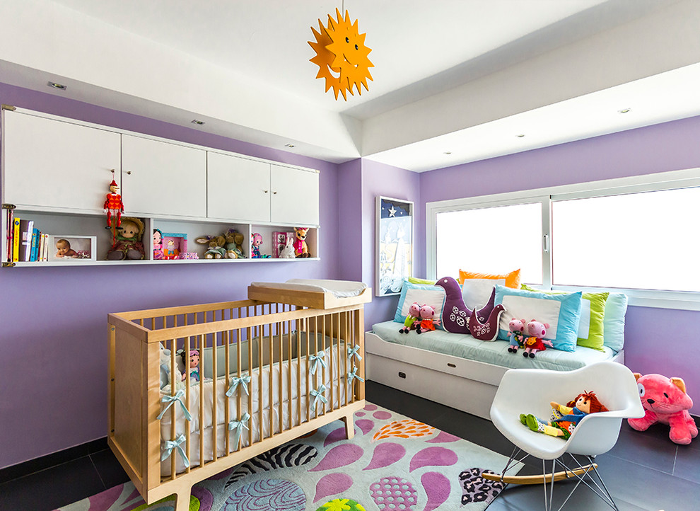 Ejemplo de habitación de bebé niña contemporánea pequeña con paredes púrpuras, suelo de baldosas de porcelana y suelo negro