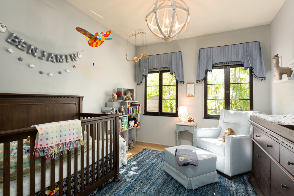 Modelo de habitación de bebé niño mediterránea de tamaño medio con paredes grises y suelo de madera clara