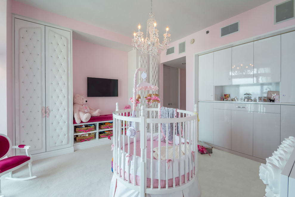 Aménagement d'une grande chambre de bébé fille classique avec un mur rose, moquette et un sol blanc.