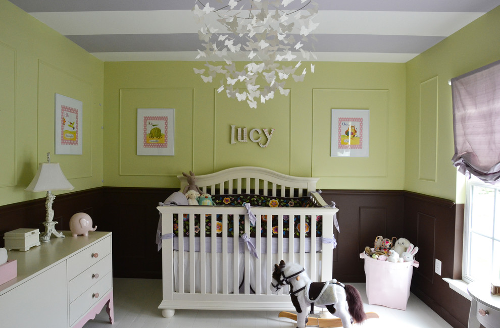 Klassisk inredning av ett babyrum, med gröna väggar och målat trägolv