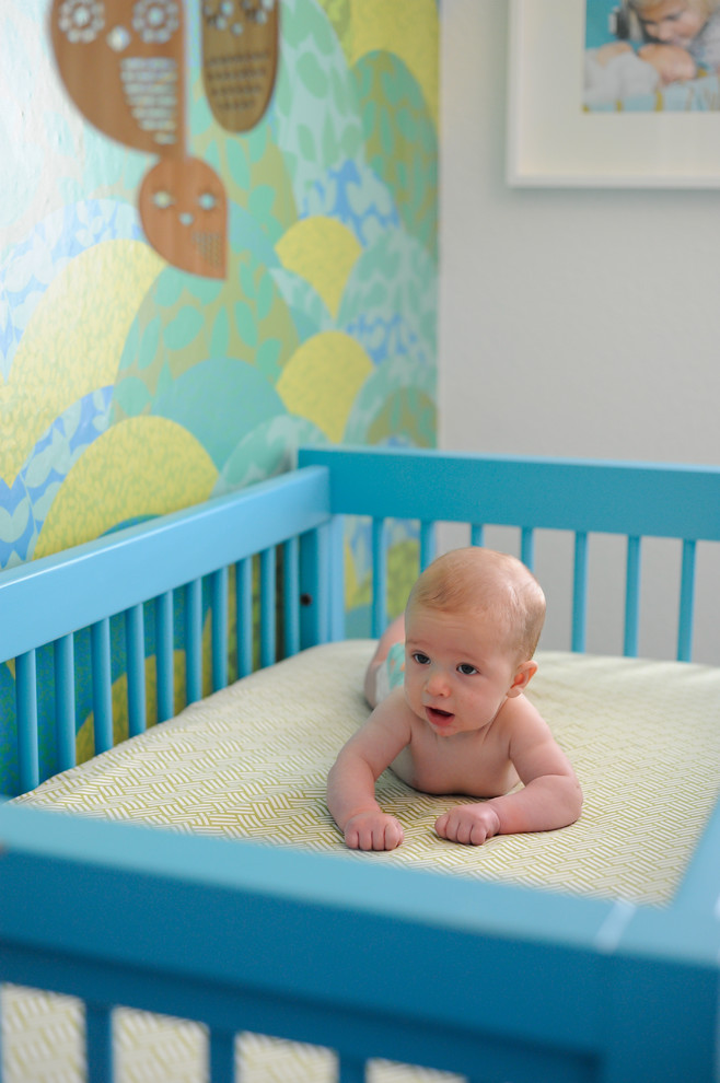 Idées déco pour une petite chambre de bébé garçon moderne avec un mur multicolore et un sol en bois brun.