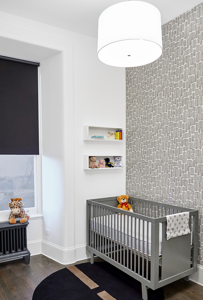 Cette image montre une petite chambre de bébé neutre design avec un mur blanc et parquet foncé.