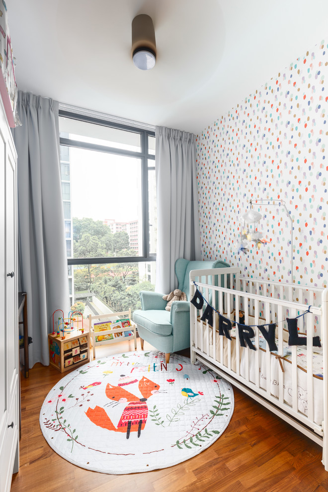 Réalisation d'une chambre de bébé neutre tradition avec un mur multicolore, un sol en bois brun et un sol marron.