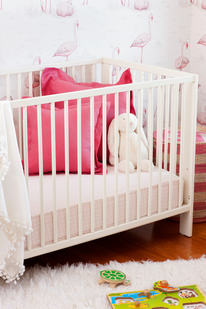 Imagen de habitación de bebé niña tradicional renovada de tamaño medio con paredes multicolor y suelo de madera en tonos medios