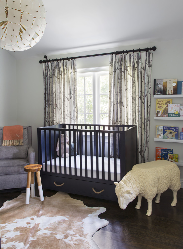 Cette photo montre une chambre de bébé neutre chic avec parquet foncé et un sol marron.