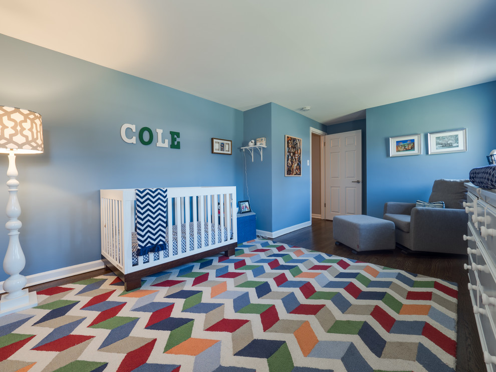 Cette photo montre une grande chambre de bébé garçon craftsman avec un mur bleu, parquet foncé et un sol marron.