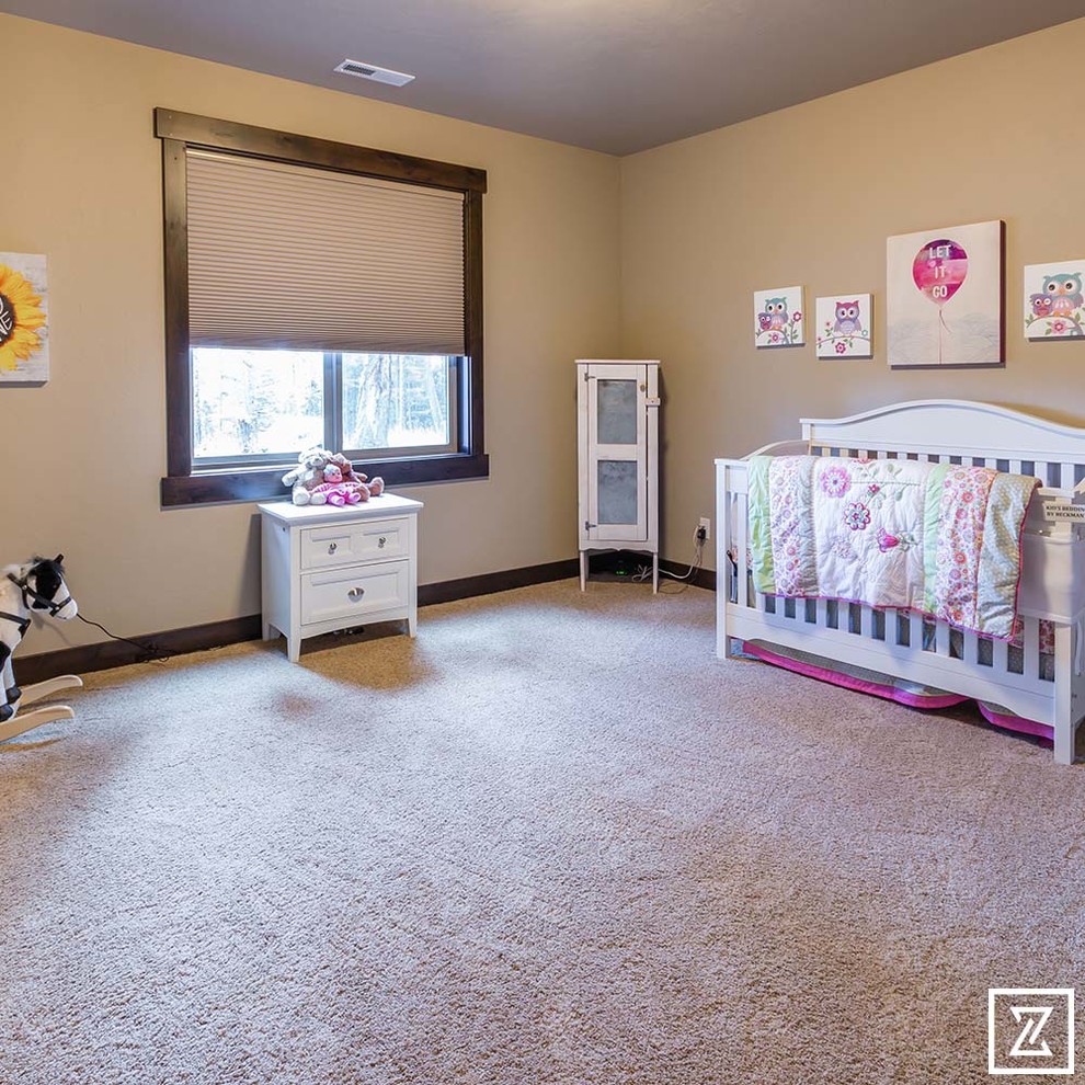 Diseño de habitación de bebé niña rural de tamaño medio con paredes beige, moqueta y suelo beige