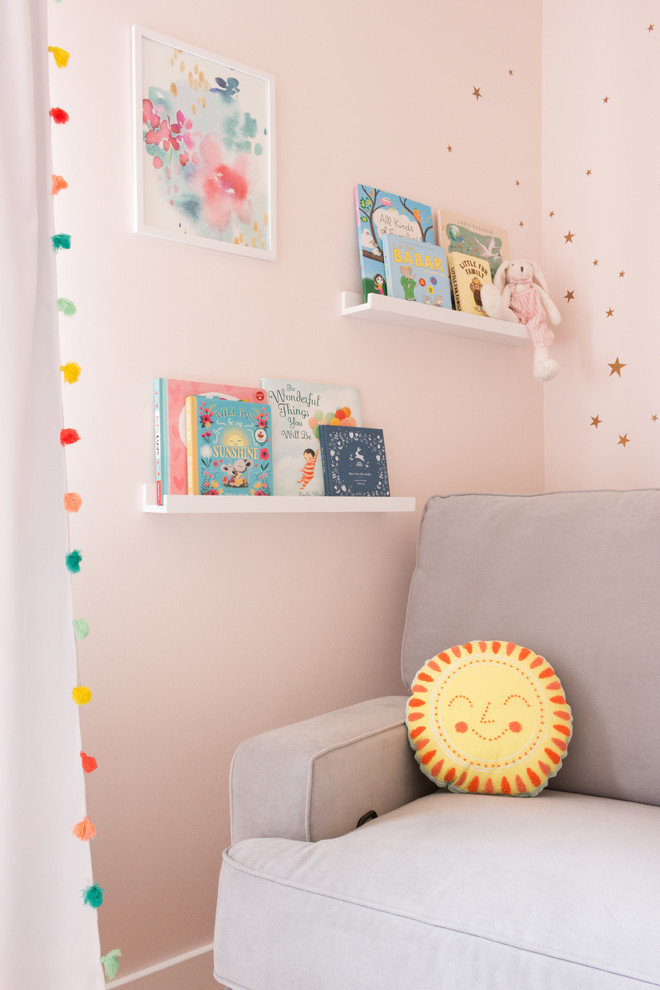 Foto di una piccola cameretta per neonata boho chic con pareti rosa, parquet chiaro e pavimento giallo