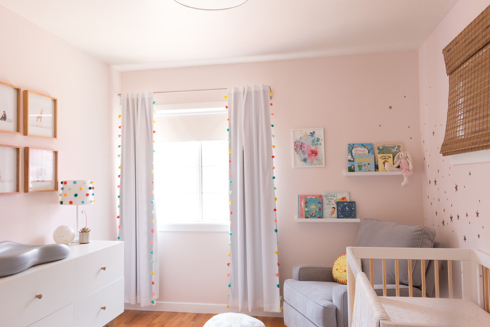 Nursery - small eclectic girl light wood floor and yellow floor nursery idea in Los Angeles with pink walls