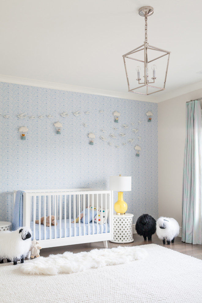 Idée de décoration pour une très grande chambre de bébé garçon tradition avec un mur bleu et parquet foncé.