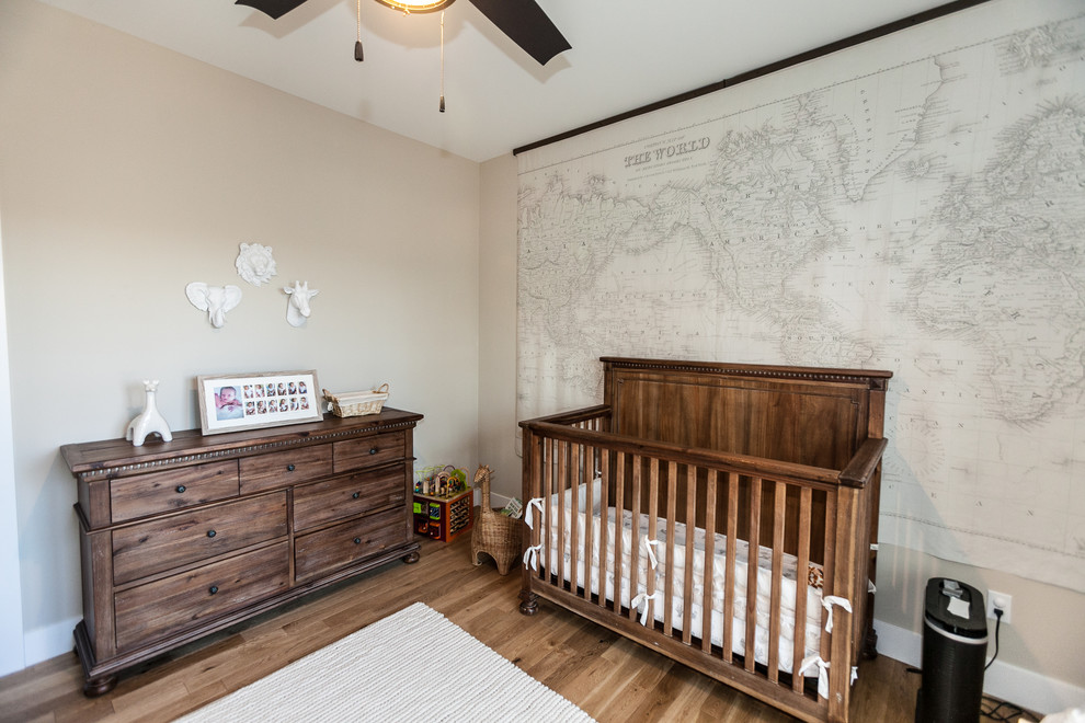 Imagen de habitación de bebé campestre con paredes beige y suelo de madera en tonos medios