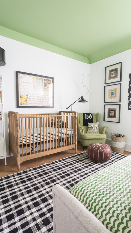 Imagen de habitación de bebé niño bohemia con paredes verdes y suelo de madera en tonos medios