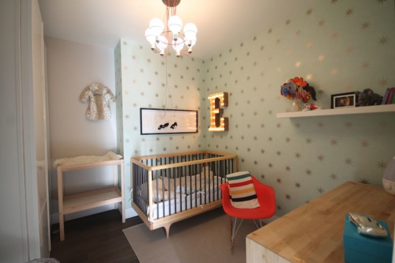 Modelo de habitación de bebé niño retro pequeña con paredes verdes, suelo de madera oscura y suelo marrón