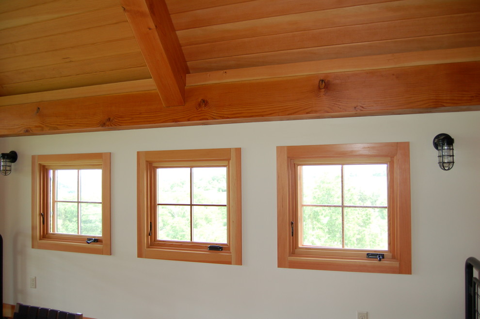 Ejemplo de habitación de bebé neutra de estilo de casa de campo grande con paredes blancas y suelo de madera en tonos medios